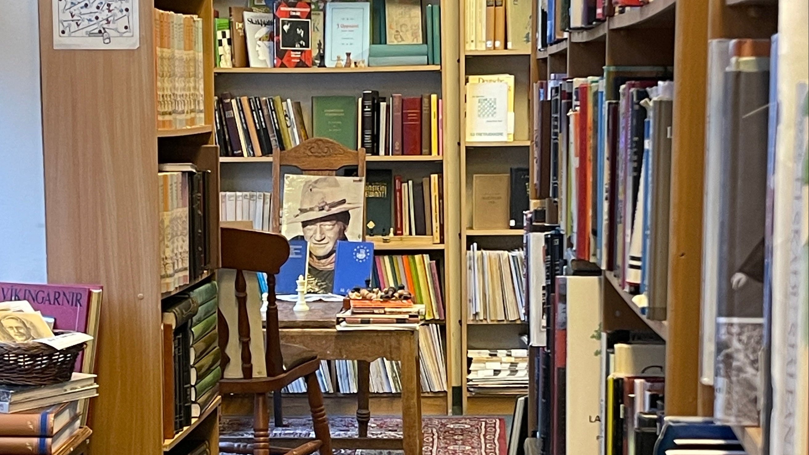 Bookshelf filled with books and a chair in a cozy bookstore setting